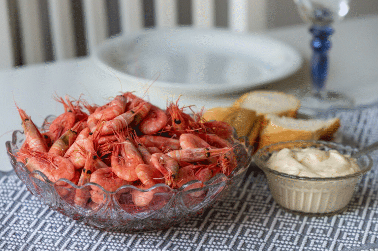 Seafood boil sauce recipe with shrimp, crab legs, corn, potatoes, and a bowl of buttery dipping sauce